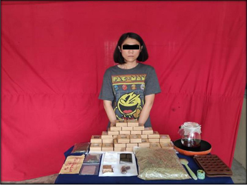 သိမ်းဆည်းရမိသည့် ဆေးခြောက်နှင့် ဆေးခြောက်အဆီဖြင့် ပြုလုပ်ထားသည့် ချောကလက်မုန့်များနှင့်အတူ တွေ့ရစဉ်။  