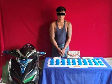 ပြစ်မှုကျူးလွန်သူအား ဖမ်းဆီးရမိသည့် စိတ်ကြွရူးသွပ်ဆေးပြားများနှင့်အတူ တွေ့ရစဉ်။