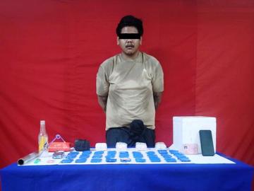 ပြစ်မှုကျူးလွန်သူအား ဖမ်းဆီးရမိသည့် စိတ်ကြွရူးသွပ်ဆေးပြားများနှင့်အတူ တွေ့ရစဉ်။